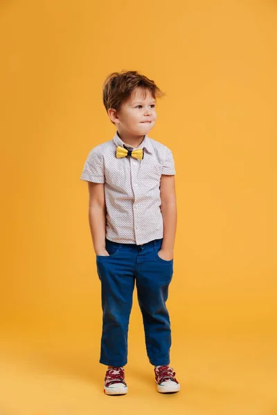 Konzentrierter kleiner Junge, der isoliert steht — Stockfoto