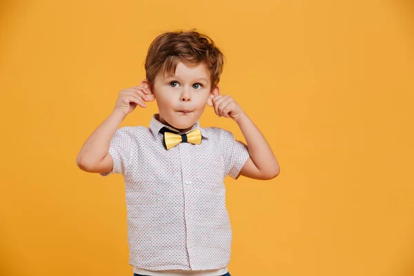 Αστεία μικρό αγόρι παιδί στέκεται απομονωθεί πάνω από το κίτρινο — Φωτογραφία Αρχείου