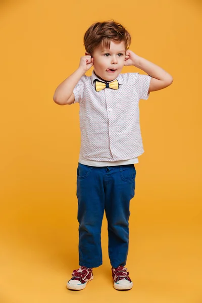 Lustiges kleines Junge Kind steht isoliert über gelb — Stockfoto