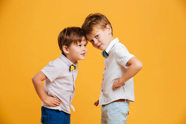 Divertidos niños hermanos aislados sobre amarillo —  Fotos de Stock