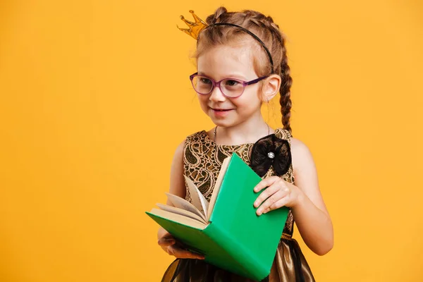 Mooi meisje kind dragen van princess crown leesboek. — Stockfoto