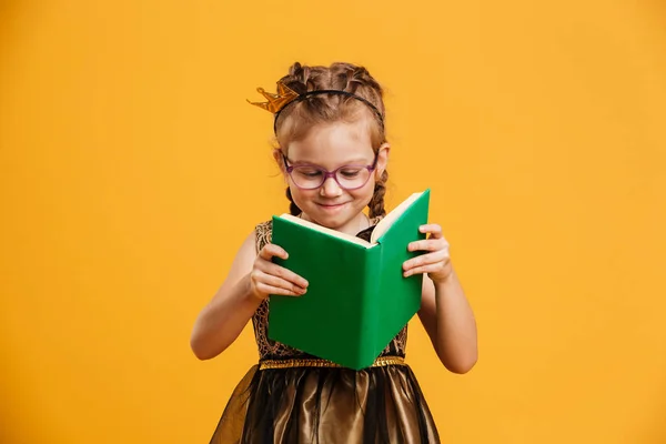 Mooi meisje kind dragen van princess crown leesboek. — Stockfoto