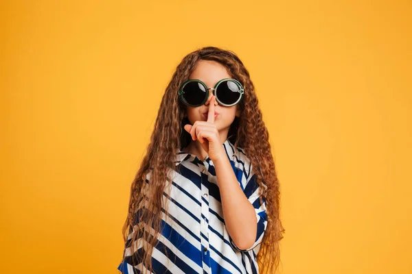 Девочка в солнечных очках показывает жест молчания . — стоковое фото