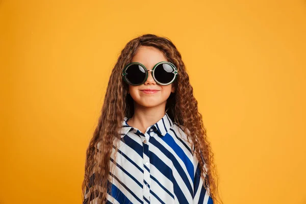 Улыбающаяся маленькая девочка в солнечных очках . — стоковое фото