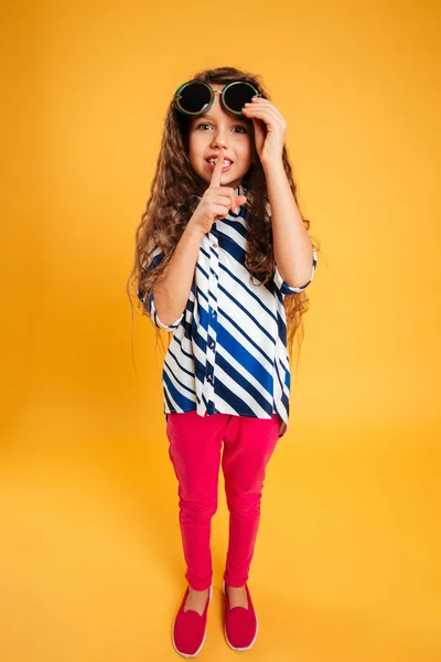 Маленька дівчинка в сонцезахисних окулярах показує жест мовчання . — стокове фото