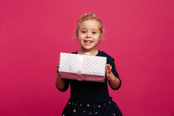 Menina feliz segurando caixa de presente e olhando para a câmera — Fotografia de Stock