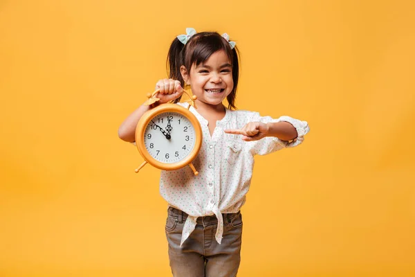 Smiling little girl child holding clock alarm. — Stock Photo, Image