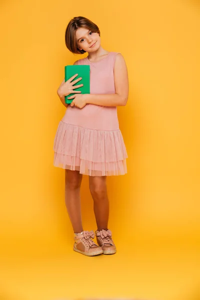 Vrij peinzende meisje op zoek camera en bedrijf groene boek geïsoleerd — Stockfoto