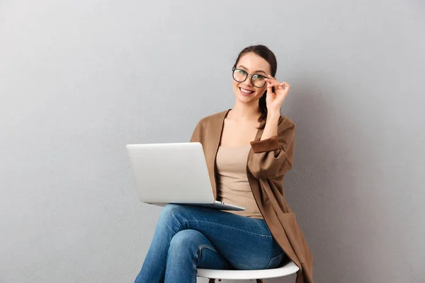 Retrato de uma mulher de negócios casual sorridente segurando laptop — Fotografia de Stock