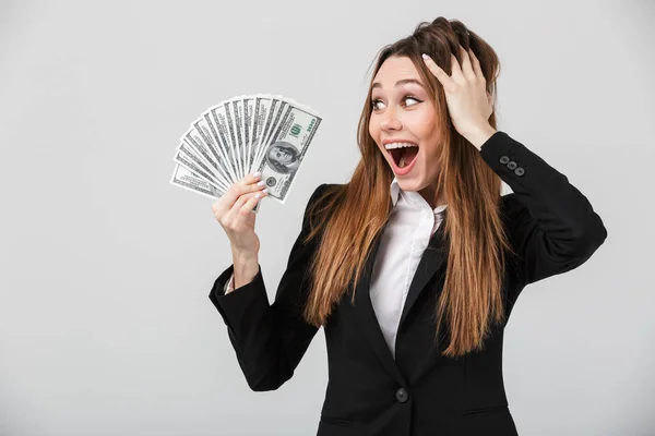 Νεαρή γυναίκα ευτυχισμένη κοιτάζοντας δολάρια στο χέρι της και χαμογελώντας απομονωμένες — Φωτογραφία Αρχείου