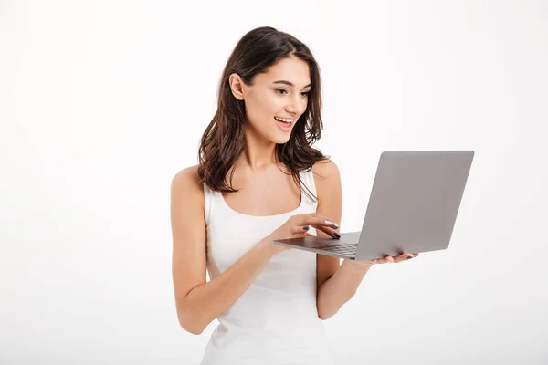 Retrato de una chica bonita vestida con camiseta sin mangas usando laptop —  Fotos de Stock