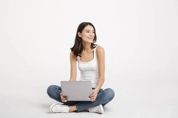 Porträtt av en glad flicka klädd i linne innehav laptop — Stockfoto
