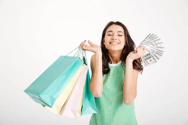 Retrato de uma menina feliz no vestido segurando sacos de compras — Fotografia de Stock