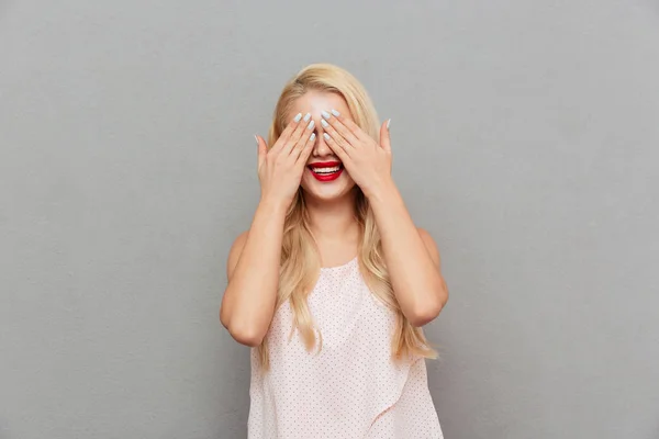 Portret van een gelukkige vrouw die betrekking hebben op ogen met handen — Stockfoto