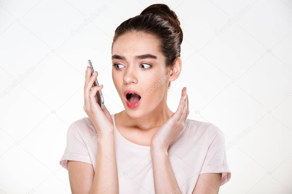 Emotional woman with brown hair in bun expressing surprise while