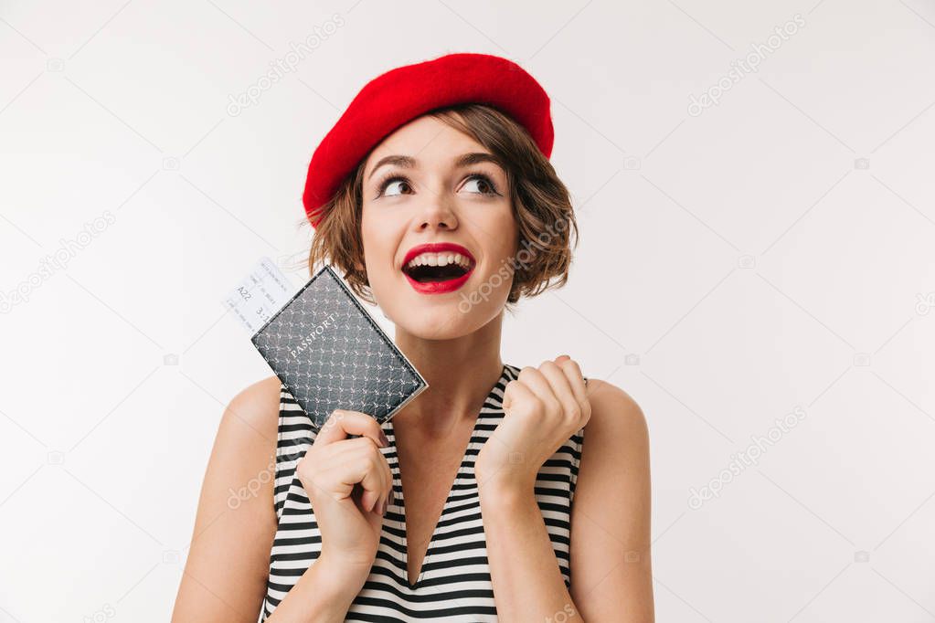 Portrait of a joyful woman wearing red beret holding passport