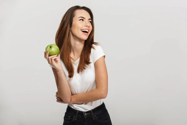 Portrait of a cheerful young woman holding green apple — Stock Photo, Image