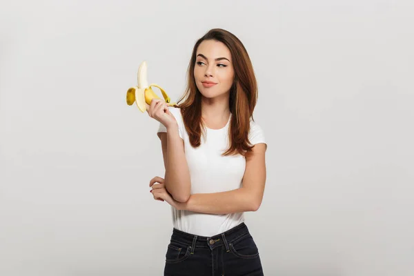 Portret młoda kobieta, patrząc na banana — Zdjęcie stockowe