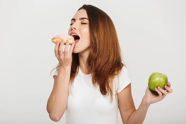 Retrato de una joven satisfecha comiendo rosquilla — Foto de Stock