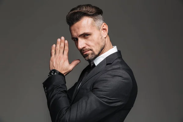 Foto in profiel van elegante volwassen man 30s in zwart pak op zoek — Stockfoto