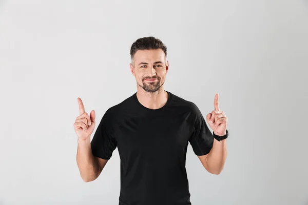 Retrato de um jovem desportista sorridente apontando os dedos para cima — Fotografia de Stock