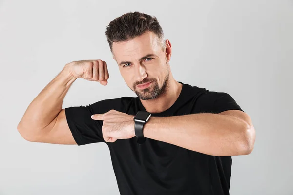 Portrait of a strong young sportsman showing biceps — Stock Photo, Image