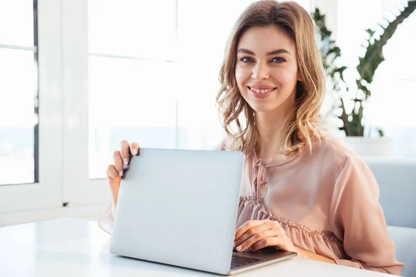 Lycklig blondy kvinna i blus som sitter vid bordet — Stockfoto