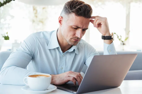 Portret zamyślony dojrzały człowiek korzysta z laptopa — Zdjęcie stockowe