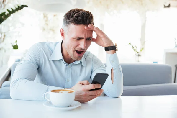 Photo of adult man being excited and puzzled while reading text — Stock Photo, Image