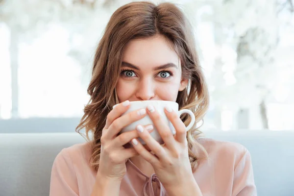Ritratto di una giovane donna allegra che tiene in mano una tazza di caffè — Foto Stock
