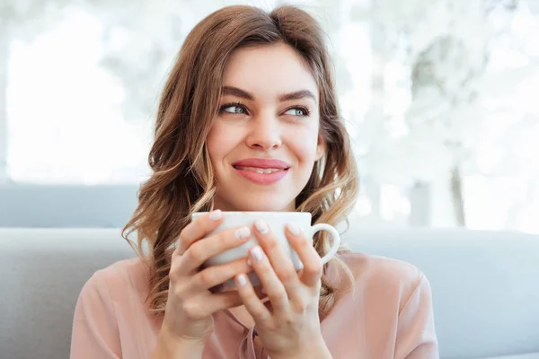 Retrato de uma jovem mulher satisfeita segurando xícara de café — Fotografia de Stock