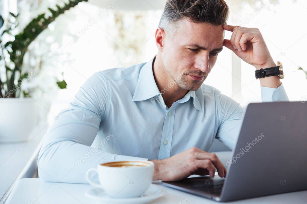 Portrait of a pensive mature man using laptop computer
