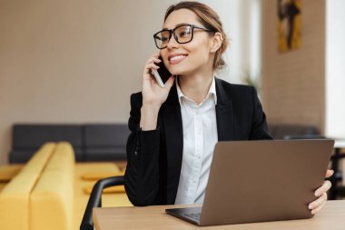 Cep telefonuyla konuşurken neşeli iş kadını