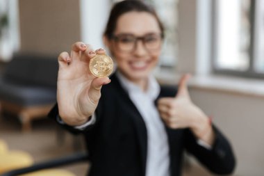 Onun altın bitcoin gösterilen genç iş kadını