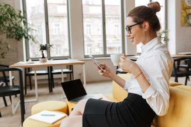 Cep telefonu kullaranarak genç mutlu iş kadını