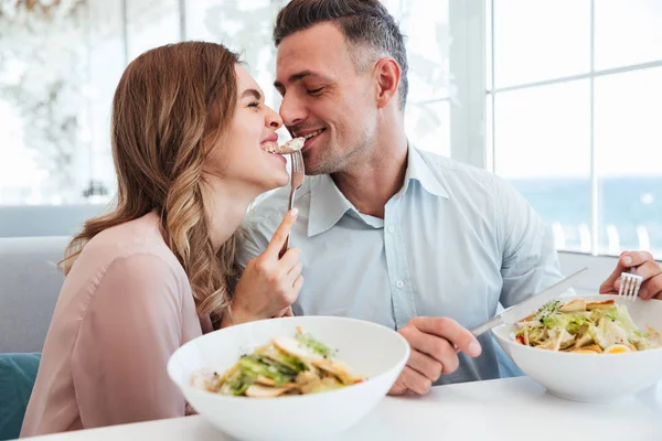 Foto von glücklichen romantischen Paar beim Abendessen und Salat essen t — Stockfoto