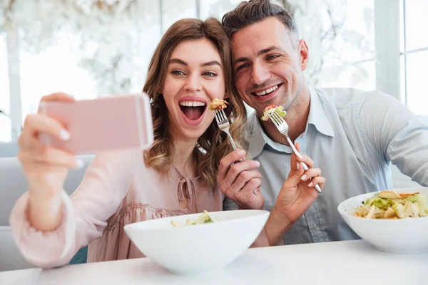 Portrait of a cheery young couple taking a selfie — Stock Photo, Image