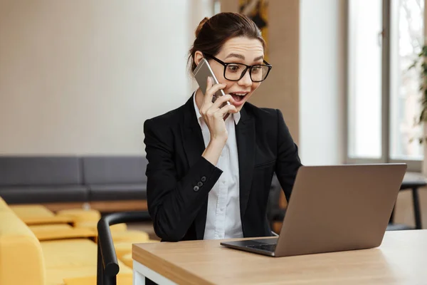 Young geschokt opgewonden zakenvrouw praten via de mobiele telefoon — Stockfoto