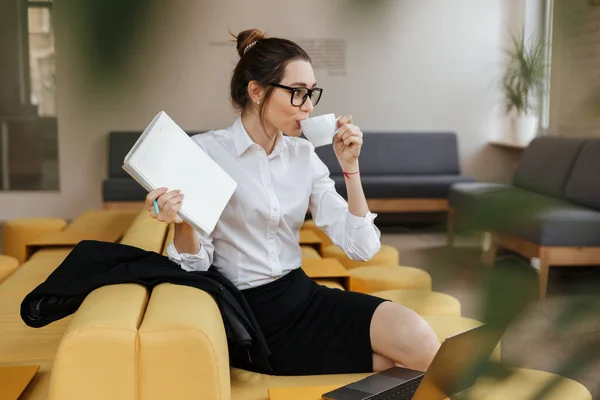 Young amazing business lady writing notes drinking coffee. — Stock Photo, Image