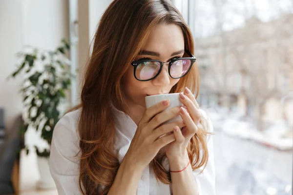 Mujer de negocios lindo sentado en el interior beber café — Foto de Stock