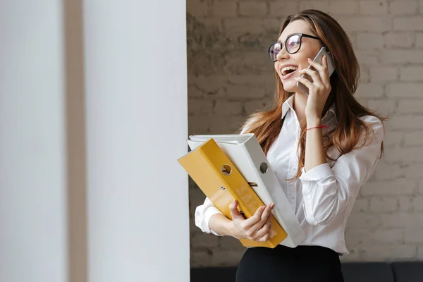 Young happy business woman holding folders looking aside. — Stock Photo, Image