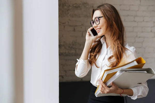 Vrolijke zakenvrouw binnenshuis praten via de mobiele telefoon — Stockfoto