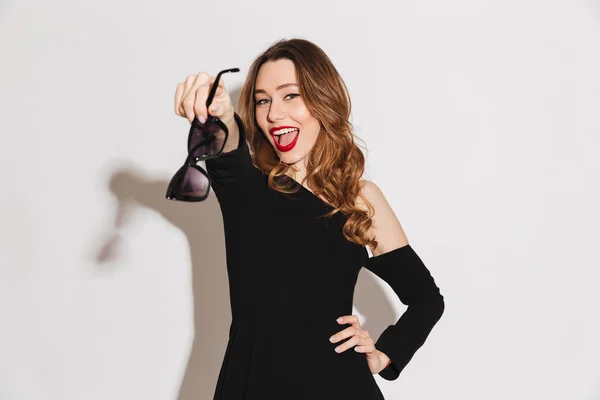 Portret van een vrolijke jonge vrouw gekleed in zwarte jurk — Stockfoto