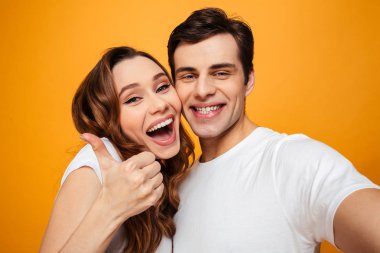 Young lovely couple posing together while making selfie and woma clipart