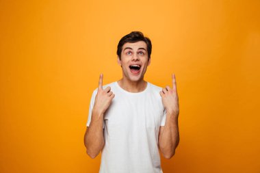 İşaret ve ararken t-shirt şaşırmış mutlu adam