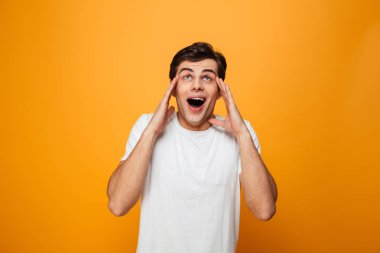 Kafa tutan ve ararken t-shirt şaşırmış şaşkın adam