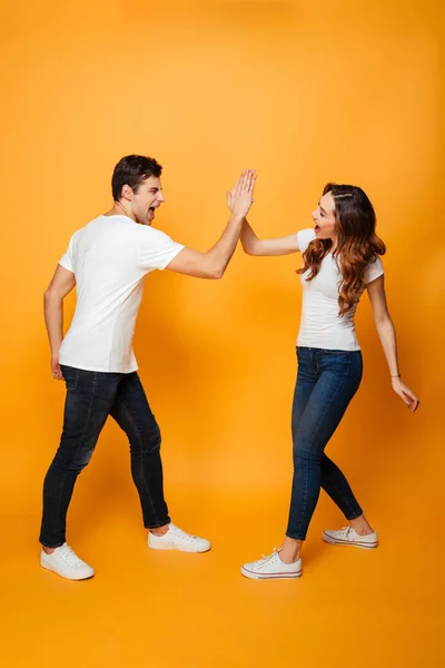 Imagem de comprimento total de feliz jovem casal gaving cinco — Fotografia de Stock