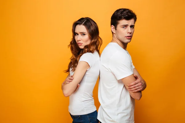 Verwirrtes junges Paar steht mit dem Rücken zueinander — Stockfoto