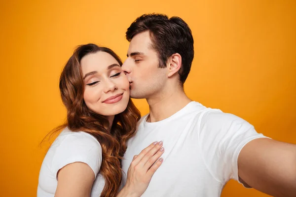 Junges reizendes Paar posiert zusammen mit gesenkten Augen — Stockfoto