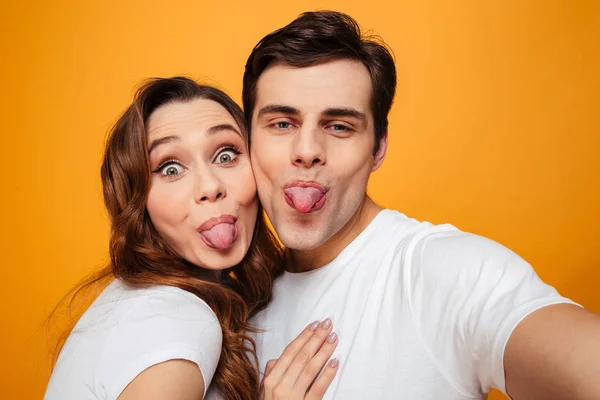 Alegre joven encantadora pareja posando juntos mientras haciendo selfie — Foto de Stock